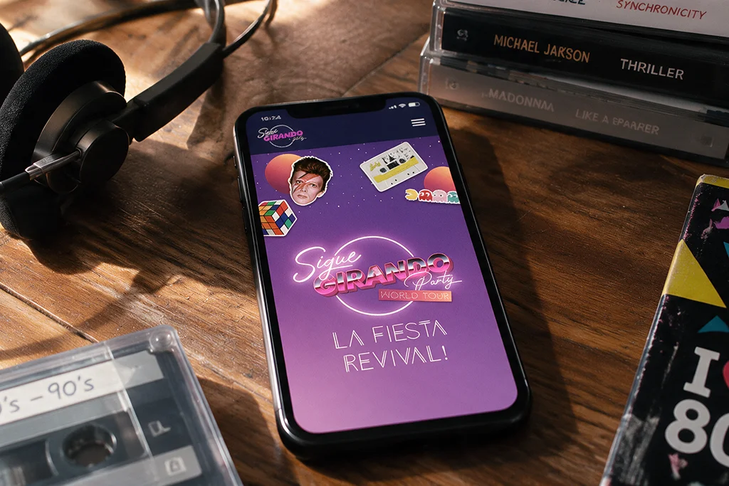 teléfono mostrando la homepage de la web de Sigue Girando Party, fiesta revival Argentina a nivel internacional, diseñada por Confetti
